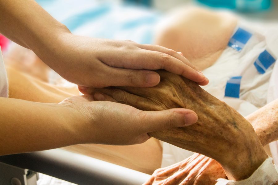 zwei junge Hände halten eine alte Hand