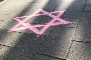 Ein Foto, welches den Davidstern mit Kreide auf den Boden gemalt draußen im Sonnenschein darstellt