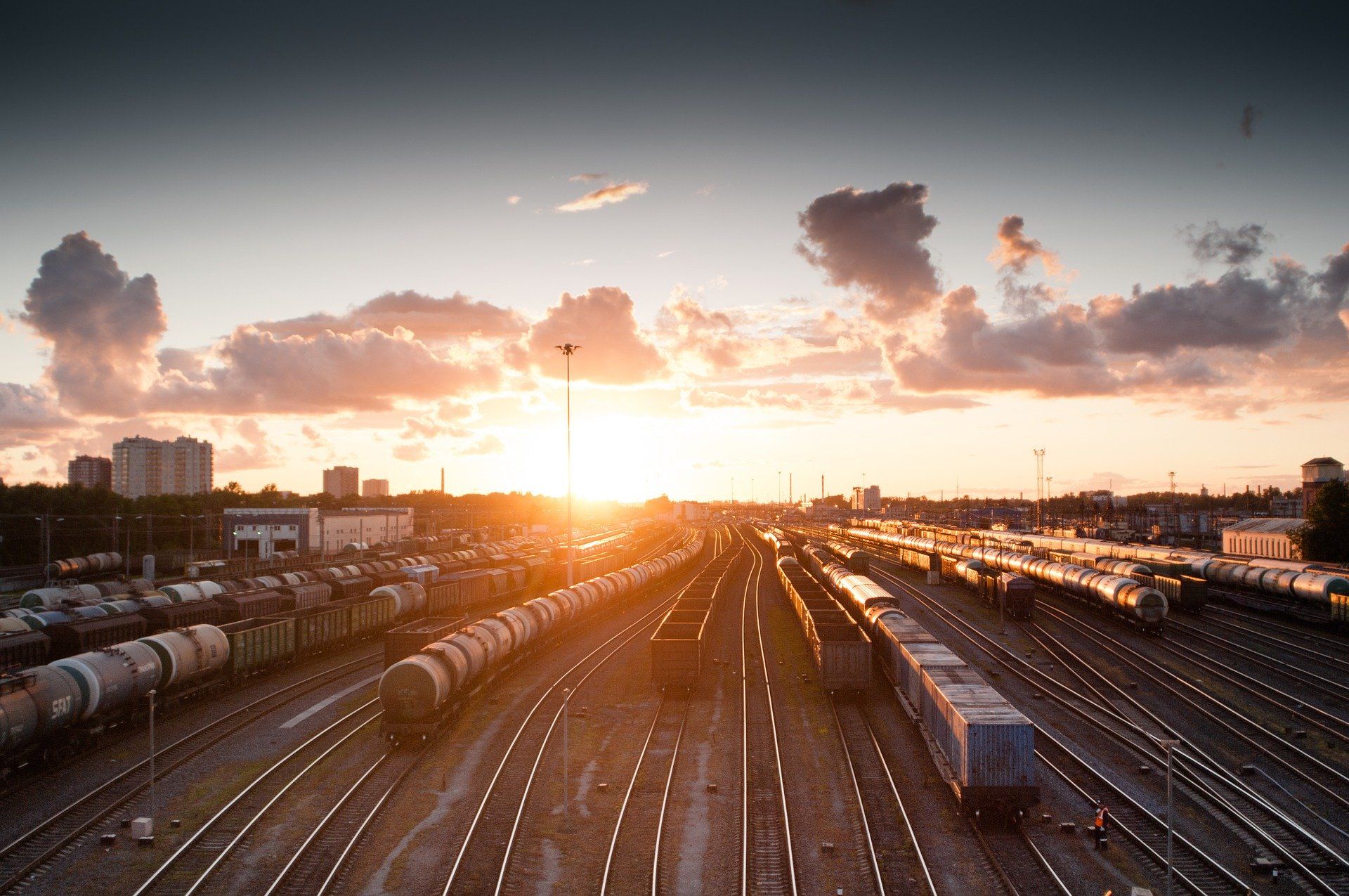 Gleise mit Zügen vor einem Sonnenuntergang
