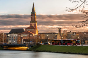 Kieler Rathaus in der Abenddämmerung. Bus, Autos und Fußgänger auf der Brücke über den Kleinen Kiel