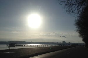 Blick auf Kiellinie mit Straße, Förde, Seebar und Kraftwerk