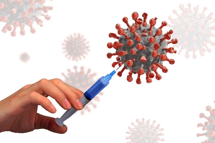 Nadel sticht in stilisiertes Coronavirus