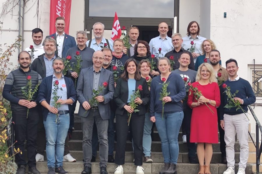 Kandidierende auf der Treppe mit Rosen in der Hand