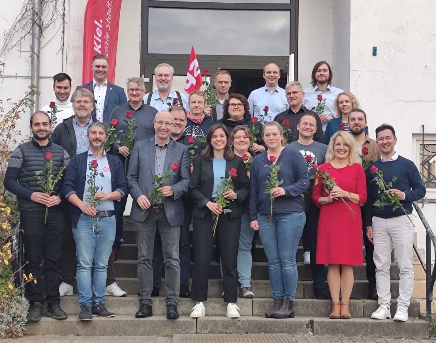Kandidierende auf der Treppe mit Rosen in der Hand