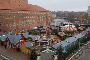 Blick von oben auf dem Weihnachtsmarkt auf dem Kieler Rathausplatz im Hellen. Im Hintergrund sind das Opernhaus und der Kleine Kiel zu sehen.