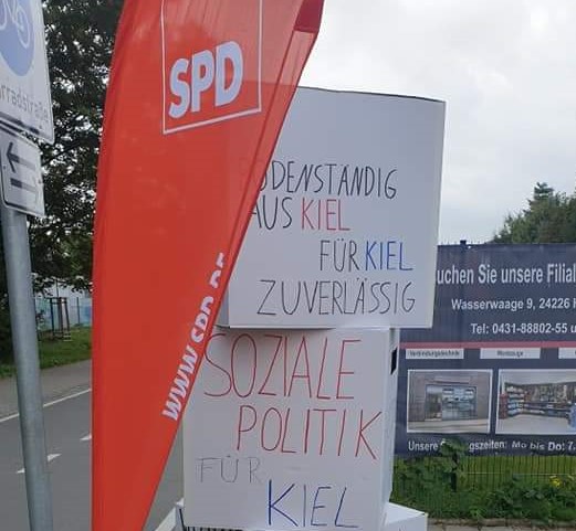Soziale Politik für Kiel - beschriftete Kartons mit einer SPD-Beachflag